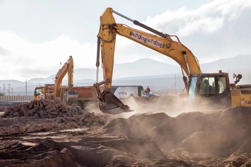 Excavadora levantando tierra en una faena industrial
