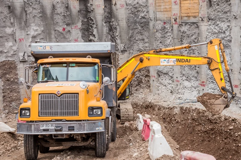 Camión y excavadora trabajando en una obra civil