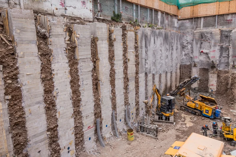 Máquinas trabajando junto a muros de contención en construcción