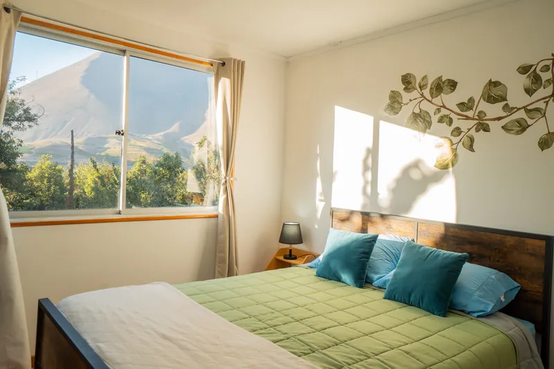 Dormitorio con ventanal y vista a los cerros