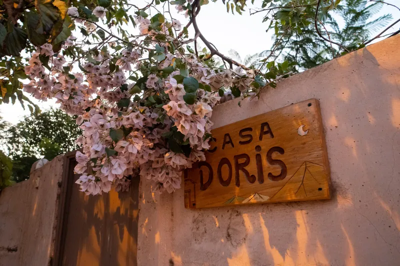 Letrero de Casa Doris entre buganvilias y vegetación