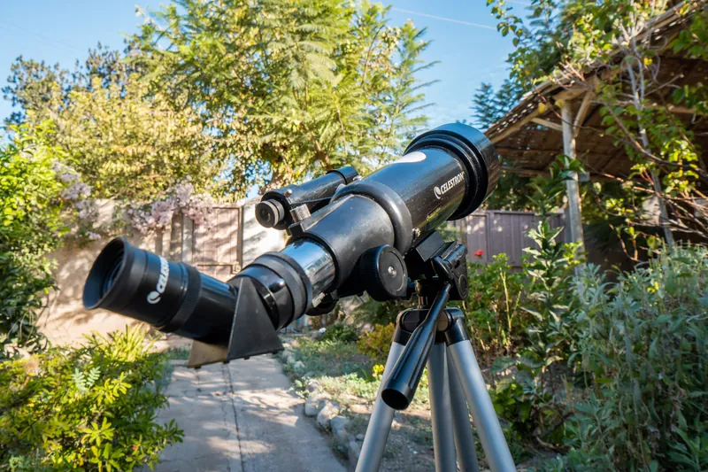 Telescopio apuntando al cielo en un jardín